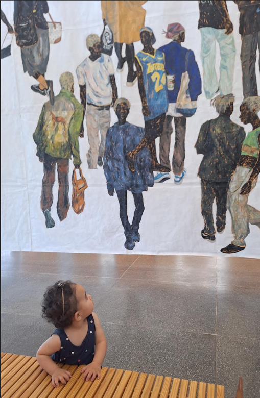 Criança olhando para um grande mural em um museu