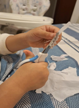 Criança cortando papéis com tesoura infantil